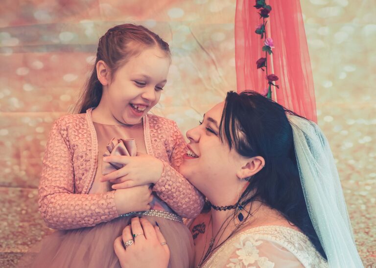 A bride and her daughter laughing together on her wedding day at the Tithe Barn Sproughton on a wedding day taken by Suffolk Wedding Photographer Hayley Denston Photography