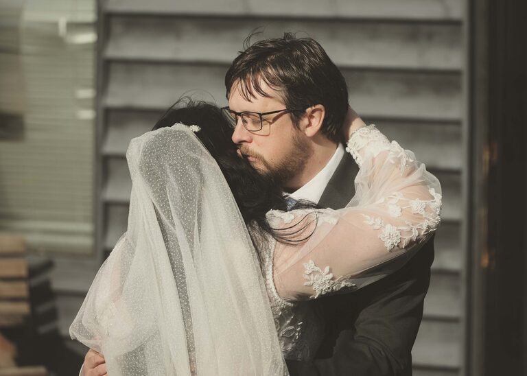 A groom hugging his bride on a wedding day at the Tithe Barn Sproughton on a wedding day taken by Suffolk Wedding Photographer Hayley Denston Photography