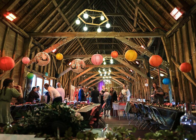 A beautiful wedding reception with multi coloured paper lanterns at the Tithe Barn Sproughton on a wedding day taken by Suffolk Wedding Photographer Hayley Denston Photography