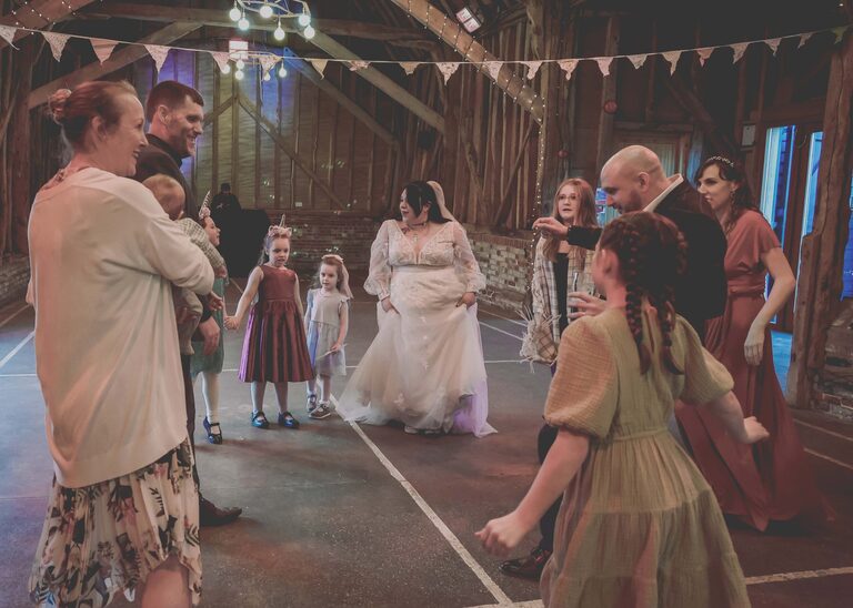 A bride dancing with children and guests on her wedding day at the Tithe Barn Sproughton on a wedding day taken by Suffolk Wedding Photographer Hayley Denston Photography