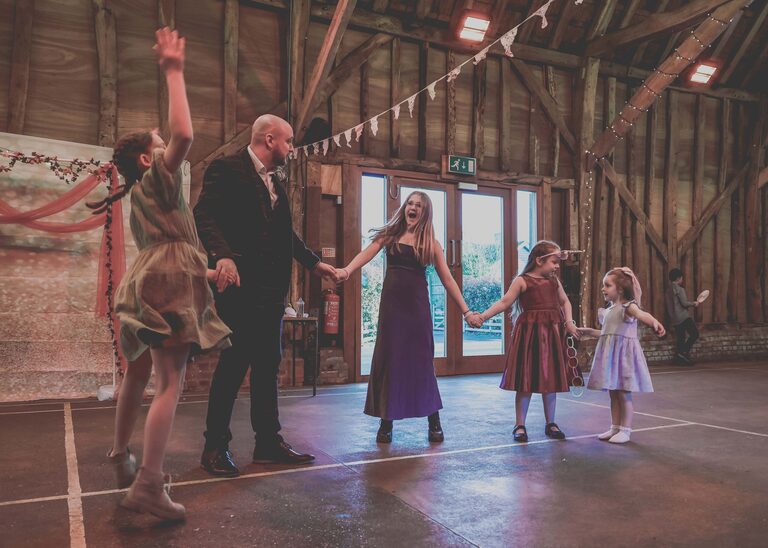 Guests doing a mexican wave at a wedding at the Tithe Barn Sproughton on a wedding day taken by Suffolk Wedding Photographer Hayley Denston Photography