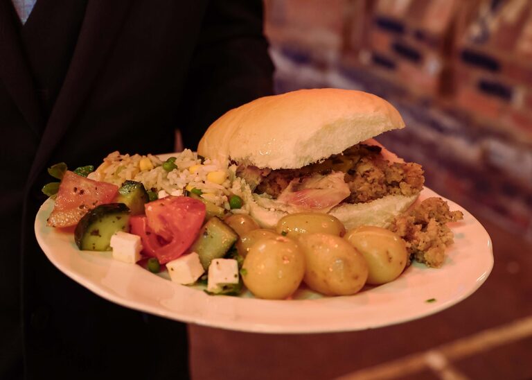 A plate of wedding food with hogroast and salads at the Tithe Barn Sproughton on a wedding day taken by Suffolk Wedding Photographer Hayley Denston Photography