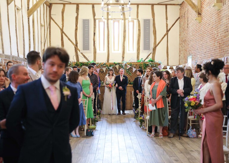 A bride at the end of the aisle with her dad on a wedding day at Bressingham Hall and High Barn captured by Suffolk Wedding Photographers Hayley Denston Photography