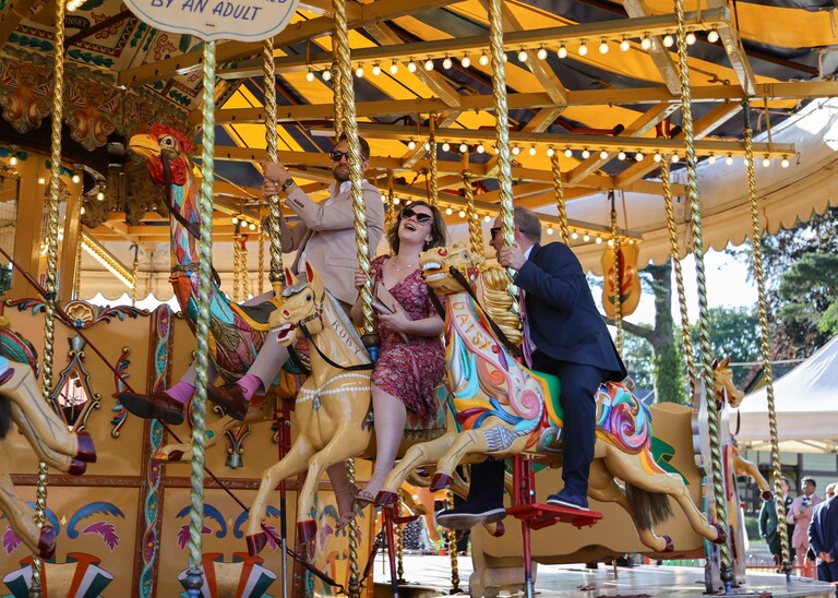 Wedding guests on the gallopers on a wedding day at Bressingham Hall and High Barn captured by Suffolk Wedding Photographers Hayley Denston Photography