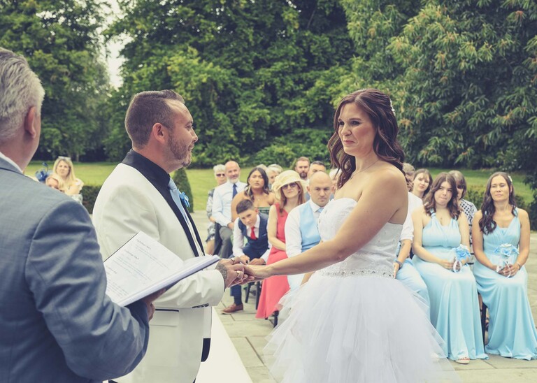 A bride and groom during their outdoor wedding ceremony on a wedding day at Swynford Manor in Suffolk Captured by Suffolk Wedding Photographer Hayley Denston Photography