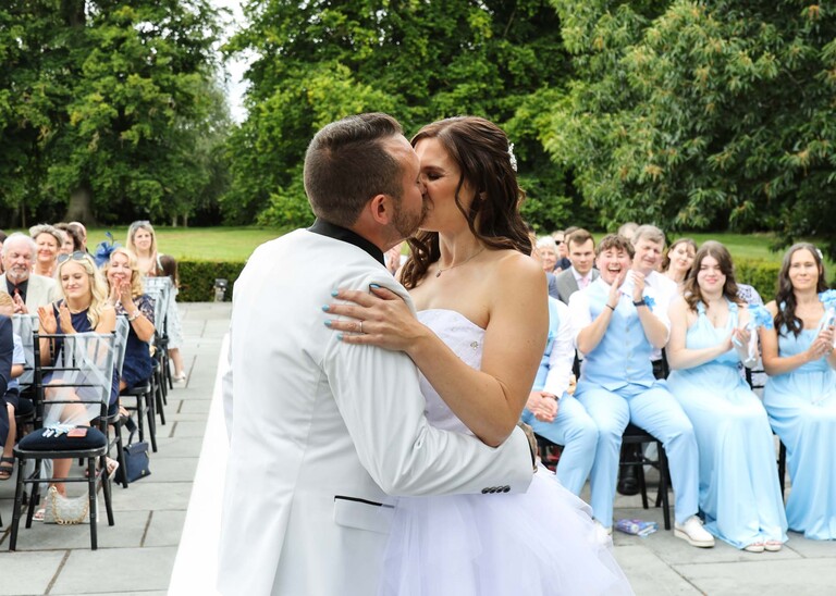 A bride and groom during their outdoor wedding ceremony on a wedding day at Swynford Manor in Suffolk Captured by Suffolk Wedding Photographer Hayley Denston Photography