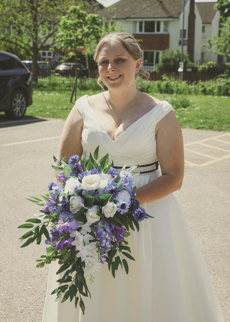 A bride stood with her bouquet in blue and white on a wedding day photographed by Suffolk Wedding Photographer Hayley Denston Photography