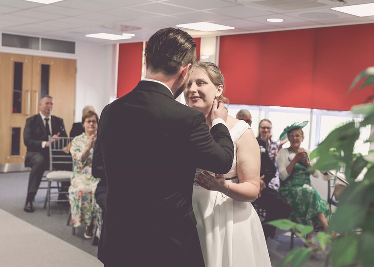 A bride smiling at her groom just after their first kiss during their wedding ceremony at Cambridge Registry Office photographed by Suffolk Wedding Photographer Hayley Denston Photography