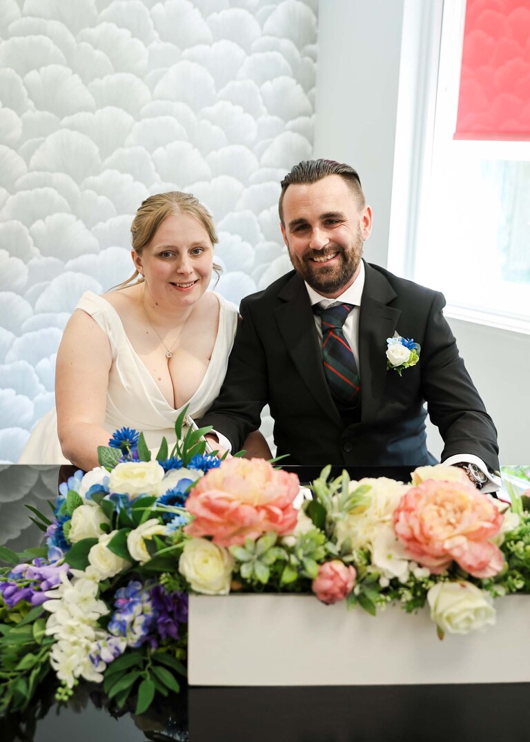 A bride and groom singing the register during their wedding ceremony at Cambridge Registry Office photographed by Suffolk Wedding Photographer Hayley Denston Photography