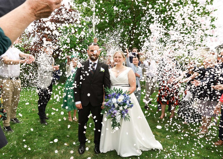 A bride and groom covered with lots of confetti at Cambridge Registry Office  photographed by Suffolk Wedding Photographer Hayley Denston Photography