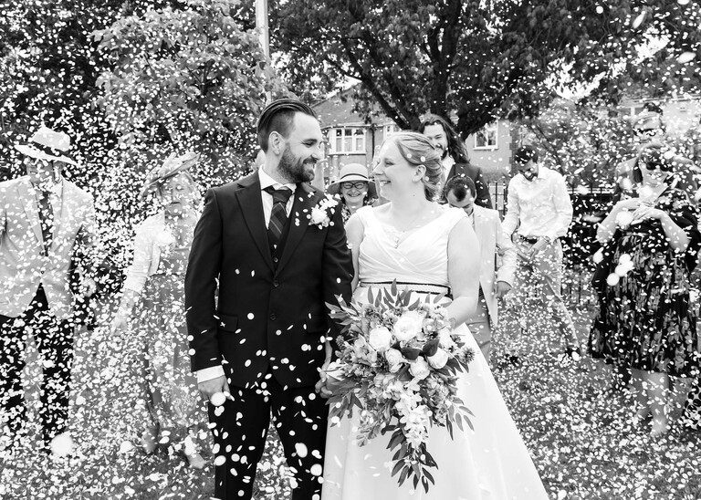 A bride and groom covered with lots of confetti at Cambridge Registry Office  photographed by Suffolk Wedding Photographer Hayley Denston Photography