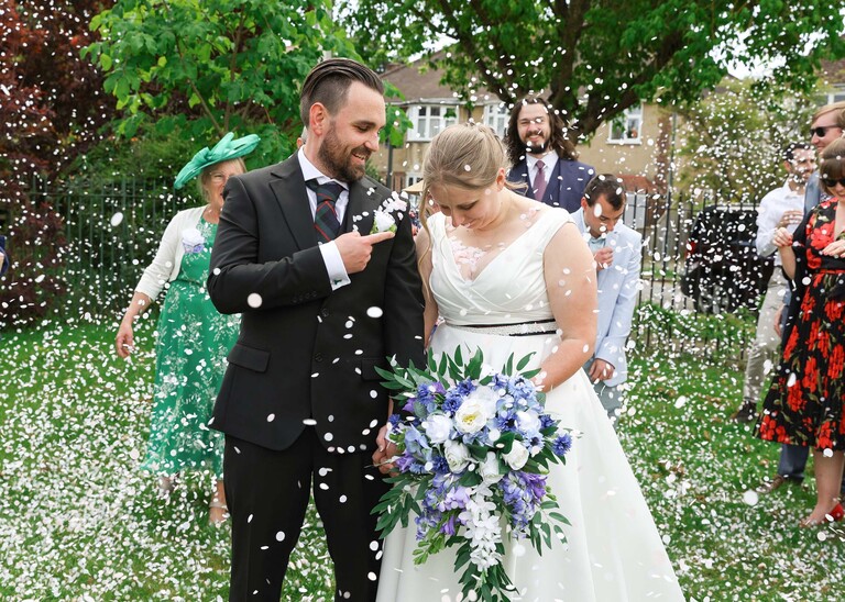 A bride and groom covered with lots of confetti at Cambridge Registry Office  photographed by Suffolk Wedding Photographer Hayley Denston Photography