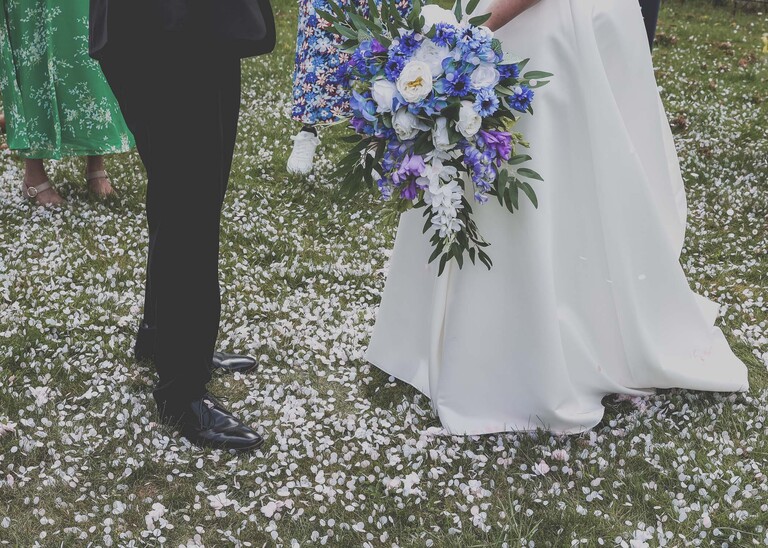 A bride and groom covered with lots of confetti at Cambridge Registry Office  photographed by Suffolk Wedding Photographer Hayley Denston Photography