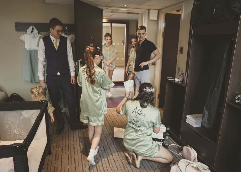 A room full of wedding party getting ready on a wedding day captured by suffolk wedding Photographer Hayley Denston Photography