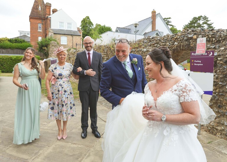 A bride and her dad leaving the hotel on a wedding day captured by suffolk wedding Photographer Hayley Denston Photography