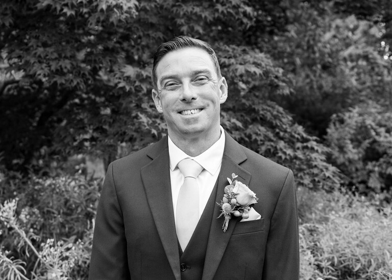 A black and white photo of a groom on a wedding day captured by suffolk wedding Photographer Hayley Denston Photography