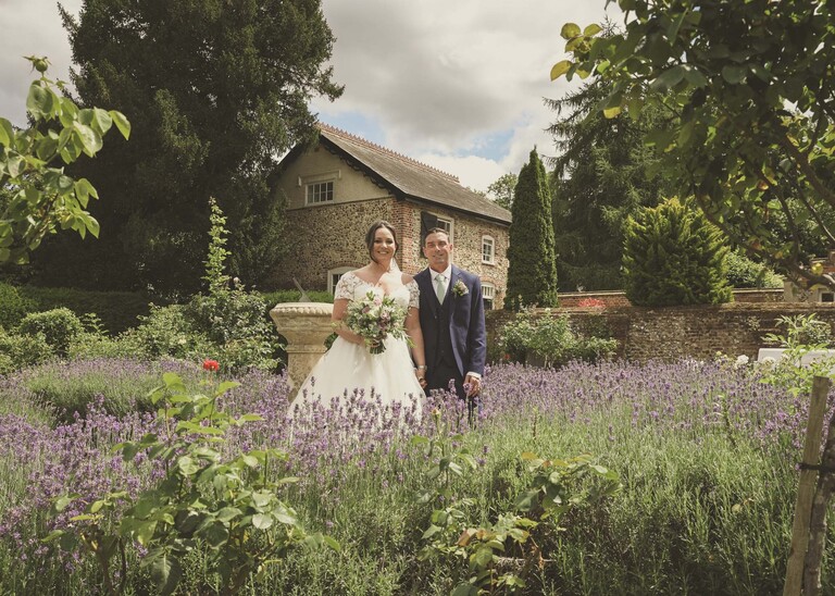 A bride and groom in amongst lavender in bury st edmunds abbey gardens on a wedding day captured by suffolk wedding photographer Hayley Denston Photography