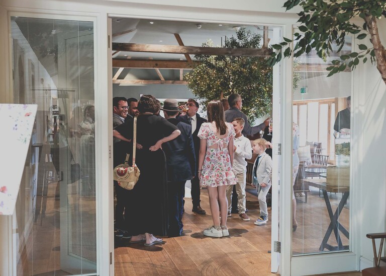 Wedding guests mingling indoors at a wedding reception on a wedding day at Easton Grange captured by Suffolk Wedding Photographer Hayley Denston Photography