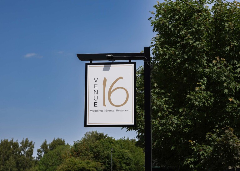 Venue 16 sign with a bright blue sky behind it on a wedding day at Venue 16 captured by suffolk wedding photographer Hayley Denston Photography