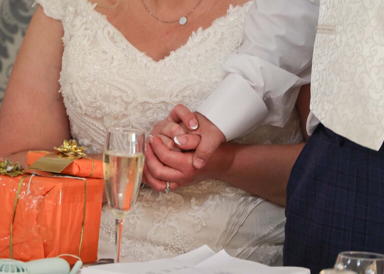 A bride squeezing the grooms hand during an emotional part of his wedding speech on a wedding day at Venue 16 captured by suffolk wedding photographer Hayley Denston Photography