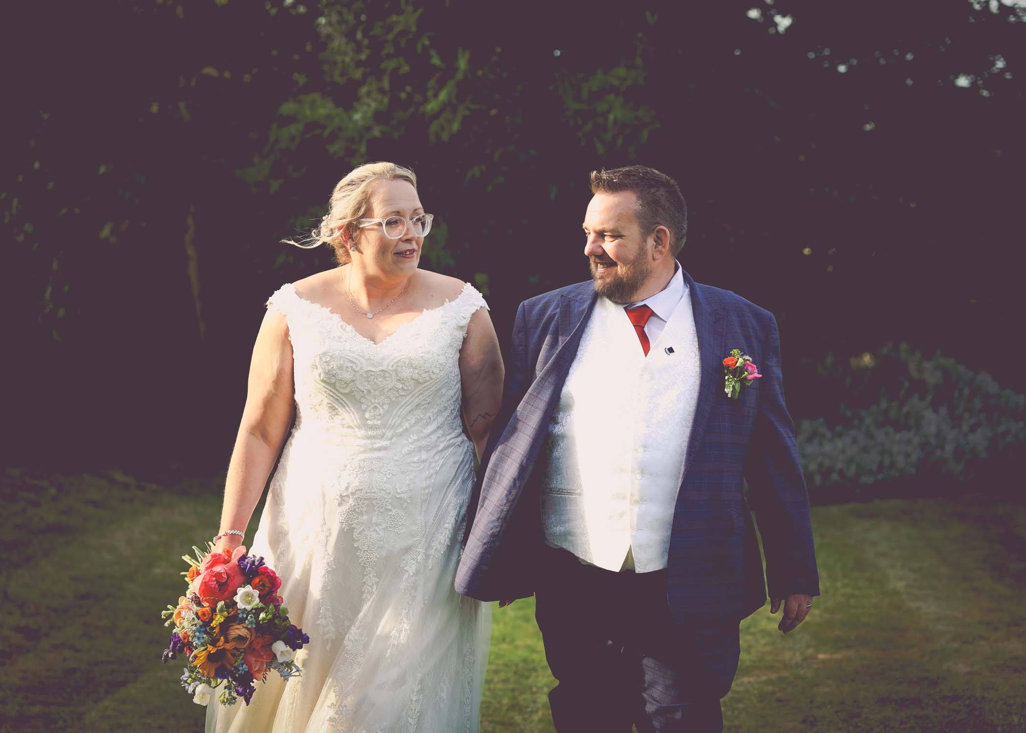 A bride and groom walking in the evening looking at each other on a wedding day at Venue 16 captured by suffolk wedding photographer Hayley Denston Photography