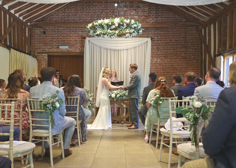 A bride and groom exchanging personal wedding vows on a wedding day at Haughley Park Barn photographed by suffolk wedding photographer Hayley Denston Photography