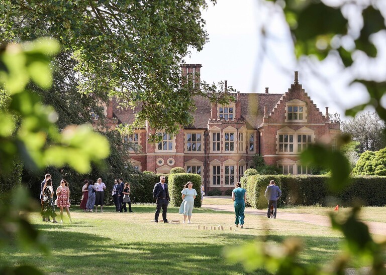 Guests enjoying lawn games at a wedding reception on a wedding day at Haughley Park Barn photographed by suffolk wedding photographer Hayley Denston Photography