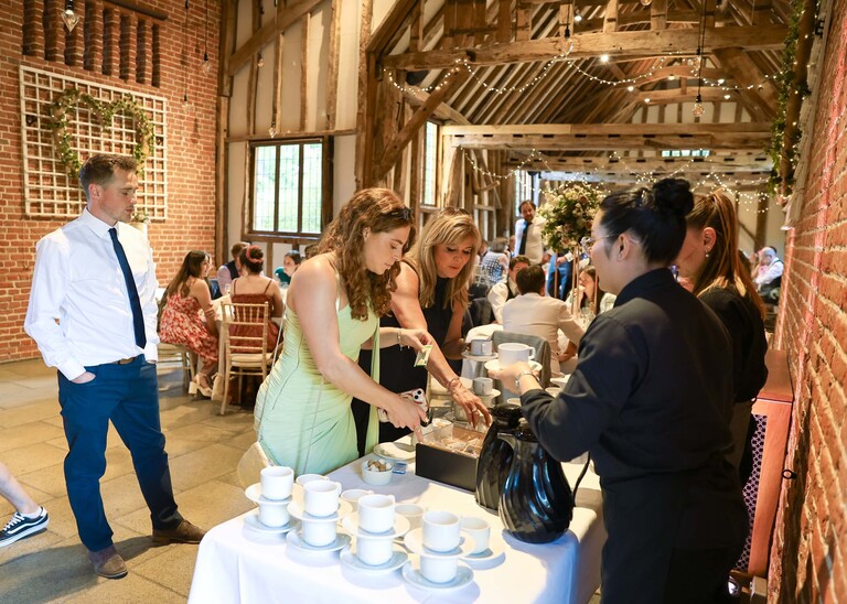 Guests getting tea and coffee during a wedding reception on a wedding day at Haughley Park Barn photographed by suffolk wedding photographer Hayley Denston Photography