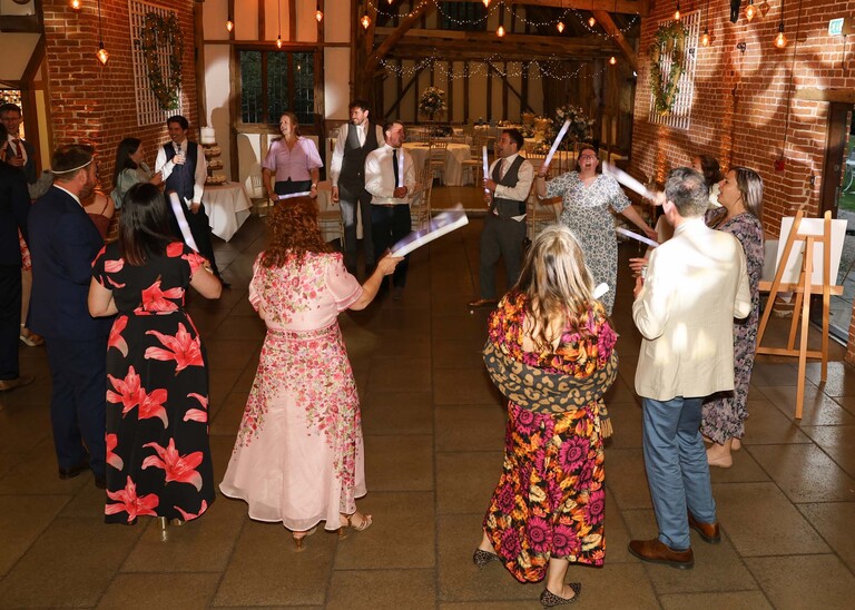 Guests dancing with glow sticks on a wedding day at Haughley Park Barn photographed by suffolk wedding photographer Hayley Denston Photography