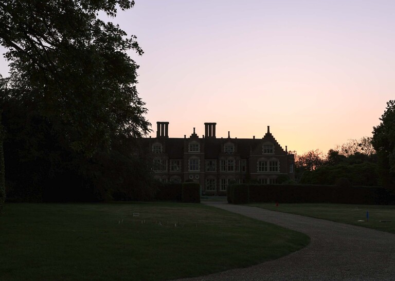 A hall silouette at sunset on a wedding day at Haughley Park Barn photographed by suffolk wedding photographer Hayley Denston Photography