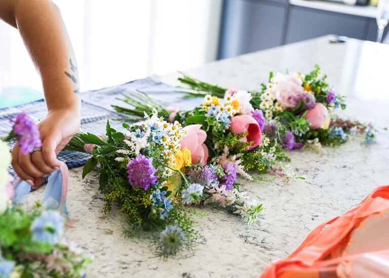 Bright bridal bouquets laying on a kitchen counter on a wedding day at Little Green Wedding Barn photographed by suffolk wedding photographer Hayley Denston Photography