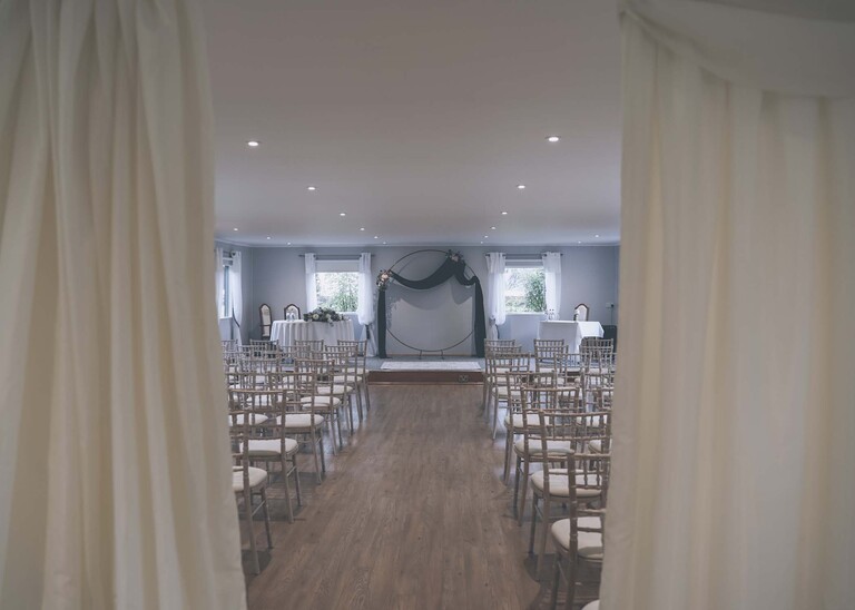 The wedding ceremony room set up through curtains  on a wedding day at Hungarian Hall Estate photographed by suffolk wedding photographer Hayley Denston Photography