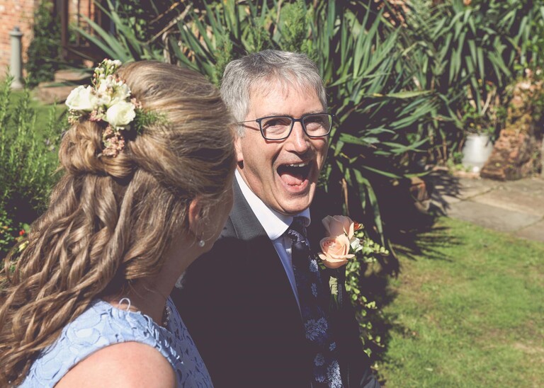 A groom laughing at his bride on a wedding day in Woodbridge captured by Suffolk Wedding Photographer Hayley Denston Photography