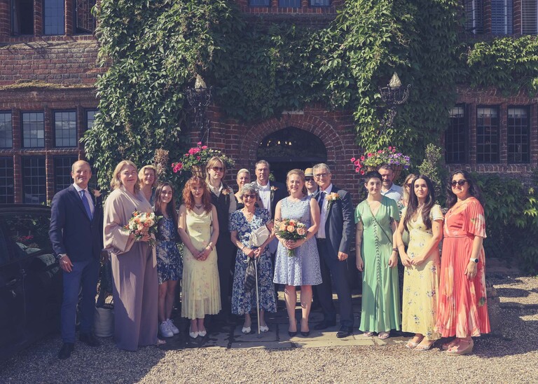 A group photo outside the front of Seckford Hall on a wedding day in Woodbridge captured by Suffolk Wedding Photographer Hayley Denston Photography