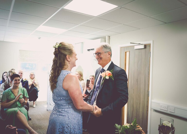 A bride and groom facing each other exchanging vows in woodbridge registry office on a wedding day in Woodbridge captured by Suffolk Wedding Photographer Hayley Denston Photography