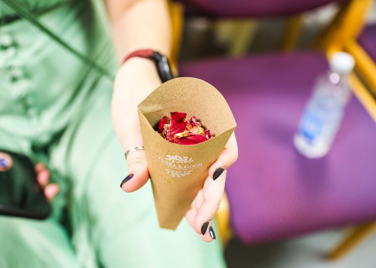 A confetti cone with bright pink rose petal confetti on a wedding day in Woodbridge captured by Suffolk Wedding Photographer Hayley Denston Photography