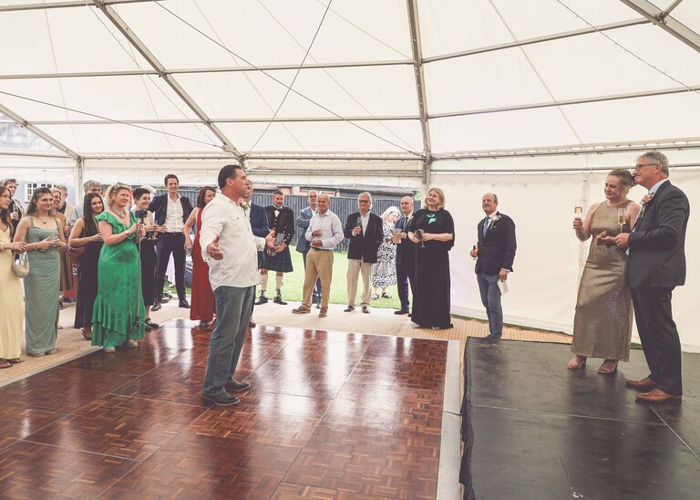 A gentleman giving a speech at an evening wedding reception at the Unruly Pig in Suffolk captured by Suffolk Wedding Photographer Hayley Denston Photography